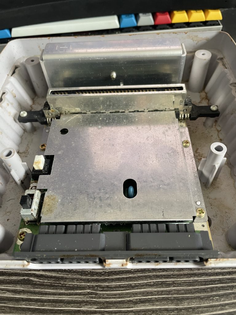 The SNES Jr. motherboard, still mounted in it's case. The RF shield is still attached.